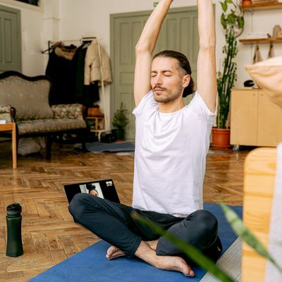 Man sitting in a calm, meditative pose after a workout session.